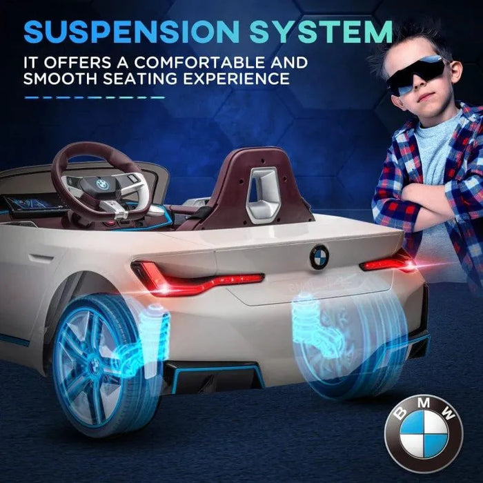 White 12V BMW i4 kids ride-on car with suspension system and a boy wearing sunglasses