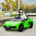 Smiling child in green 12V Lamborghini Aventador kids ride-on car with butterfly doors