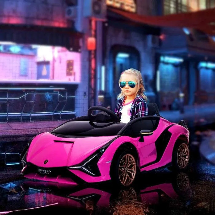 Child in sunglasses driving pink 12V Lamborghini Sian kids ride-on car on city street at night
