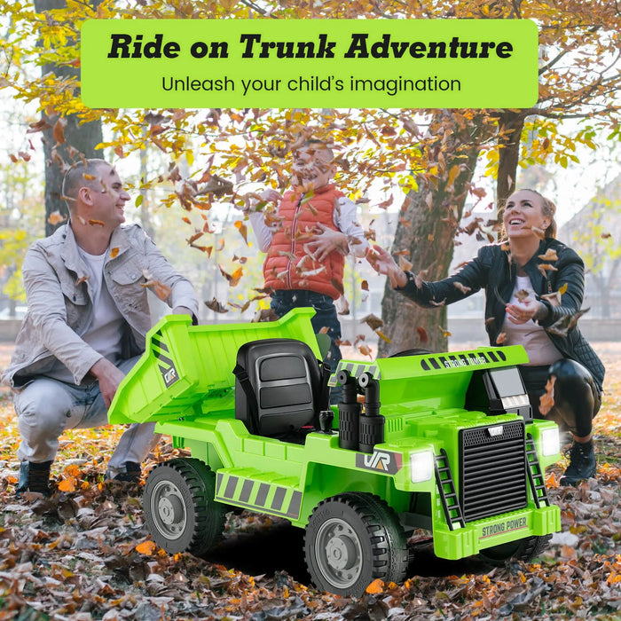 Bright green electric ride-on dump truck toy with open bed, kids playing with autumn leaves outdoors