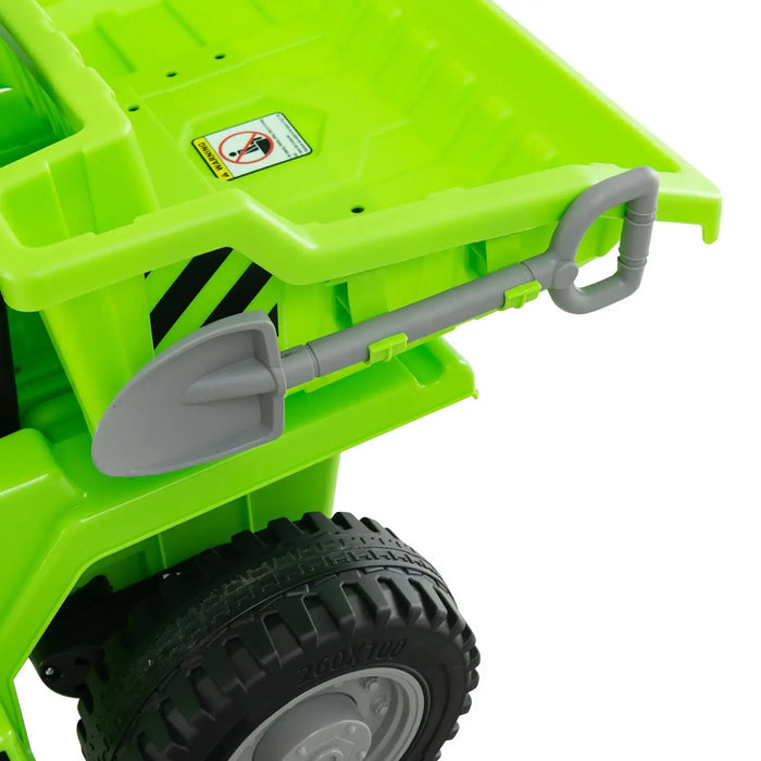 Green kids electric ride-on dump truck with attached gray toy shovel and large black tire