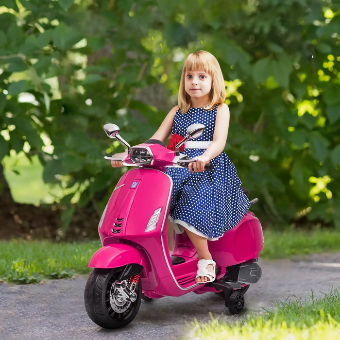 Young girl in blue polka dot dress riding pink kids electric scooter outdoors on path