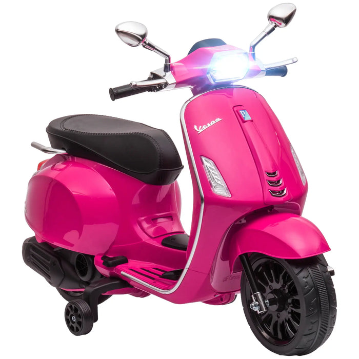 Pink Vespa scooter toy with black seat, working headlight, and training wheels on white background