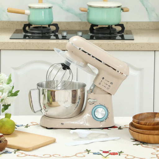 Beige stand mixer on a kitchen counter with pots on the stove in the background
