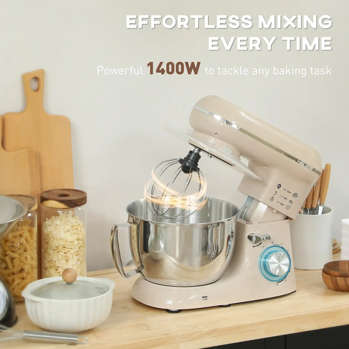 Beige stand mixer with whisk attachment on a kitchen counter, surrounded by baking ingredients.