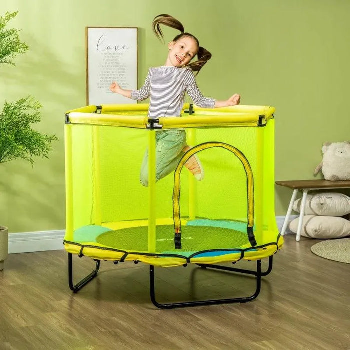 Child jumping on yellow and blue indoor square trampoline with safety net in playroom
