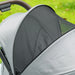 Close-up of a gray stroller with a mesh side panel on a grassy background
