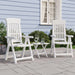 Two white garden reclining chairs with side table on patio, blue house exterior background