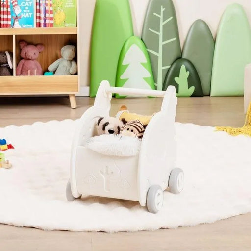 White elephant-shaped baby walker with plush toys on a rug in a playroom