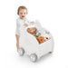 Baby pushing white elephant-shaped walker with shopping cart holding stuffed animals