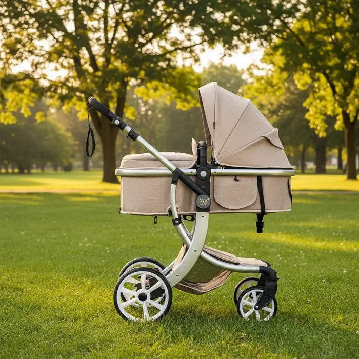 Beige baby stroller with canopy on a grassy field with trees in the background