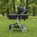 Black and white stroller on grass with trees in the background