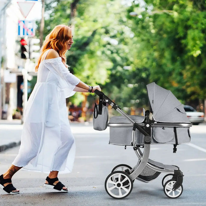 Woman pushing a stroller on a city street with greenery in the background