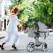 Woman pushing a stroller on a city street with greenery in the background