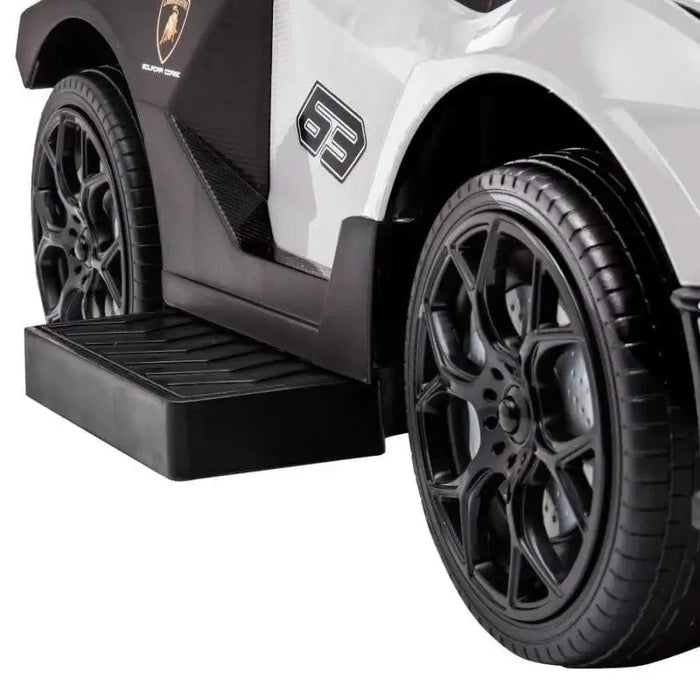 Close-up of white Lamborghini Essenza SCV12 kids ride-on car with black wheels
