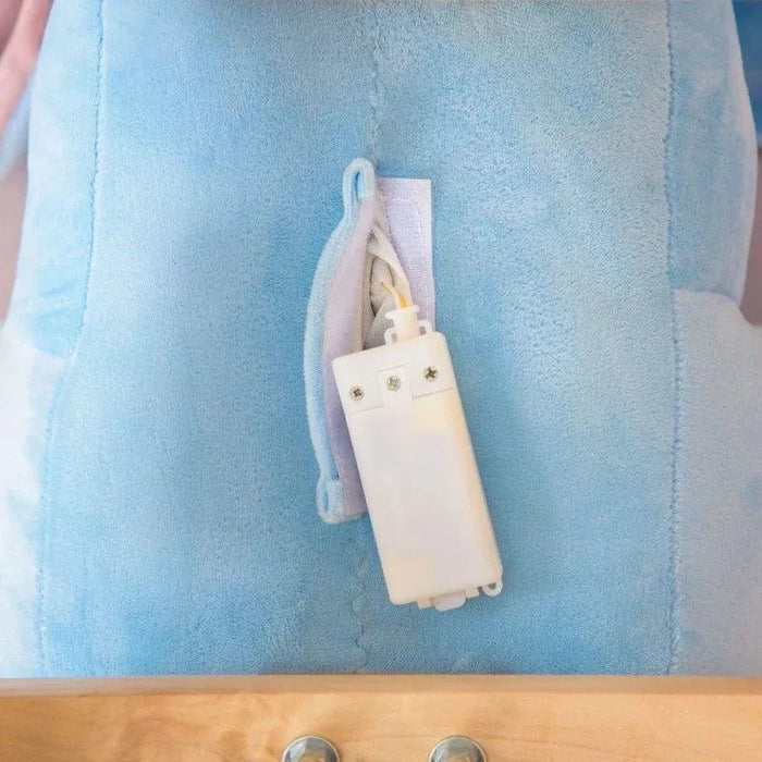 Close-up of blue plush elephant rocker with open zipper and white battery pack visible.