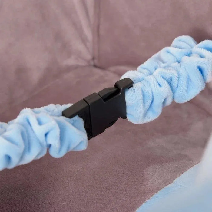 Close-up of a black seat belt buckle with light blue plush strap on a soft plush seat