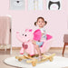 Toddler riding a pink plush rocking horse elephant in a nursery room