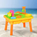 Colorful 2-in-1 sand and water sensory play table set on a sandy beach