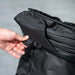Person adjusting a black jacket with a blurred background