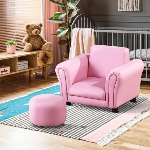 Pink 2-piece kids armchair and footstool set in a nursery with crib and teddy bear