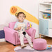 Toddler sitting on pink kids armchair set with matching footstool in playroom
