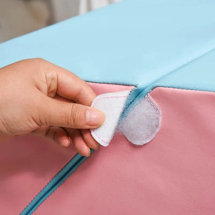Hand adjusting Velcro on pink and blue soft play equipment for kids