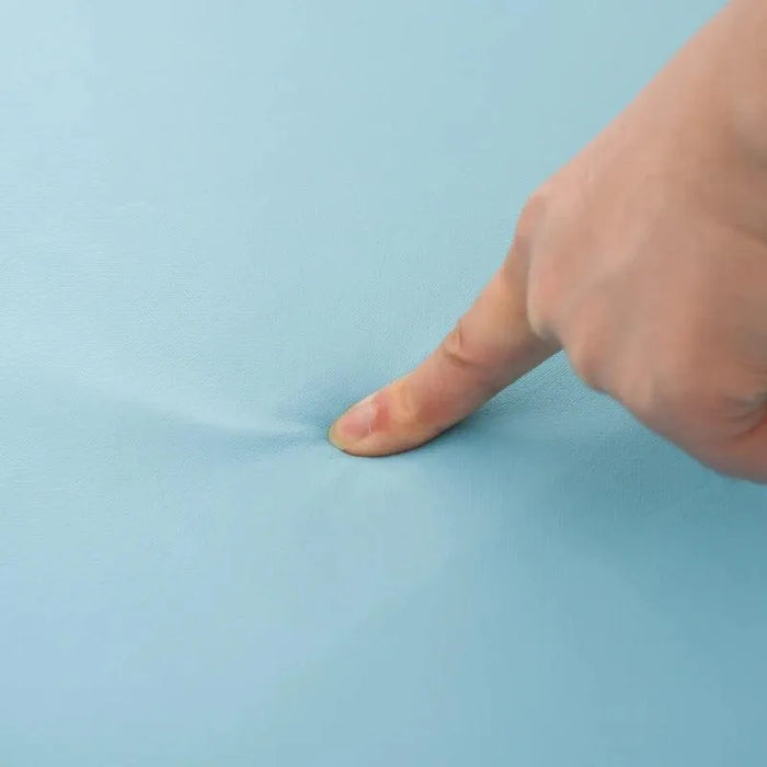 Hand pressing into soft blue foam surface of kids play equipment