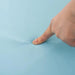 Hand pressing into soft blue foam surface of kids play equipment