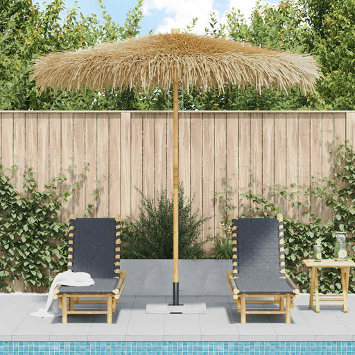 Tropical garden parasol with hand-woven roof and bamboo pole by poolside loungers