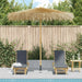 Tropical garden parasol with hand-woven roof and bamboo pole by poolside loungers