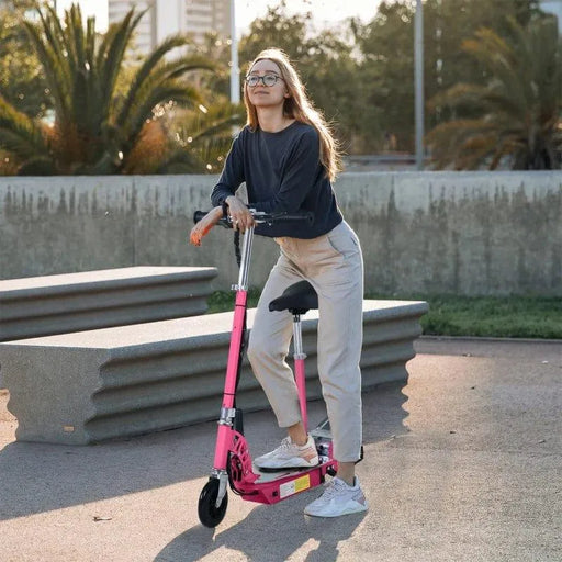Woman with glasses on a pink electric scooter with seat outdoors near concrete benches