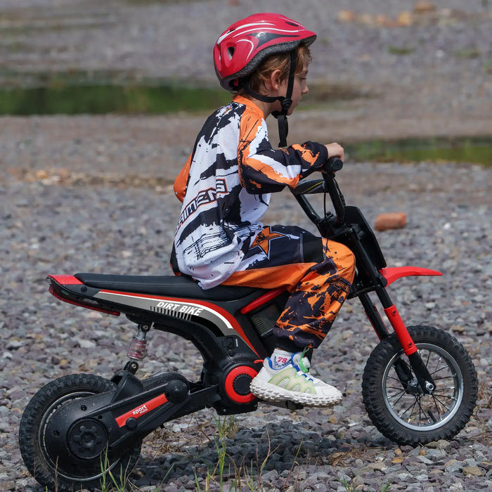 Child in helmet riding red 24V kids electric dirt bike on rocky outdoor terrain