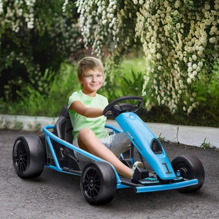 Smiling child rides blue 24V kids electric drift go-kart on outdoor path with flowers