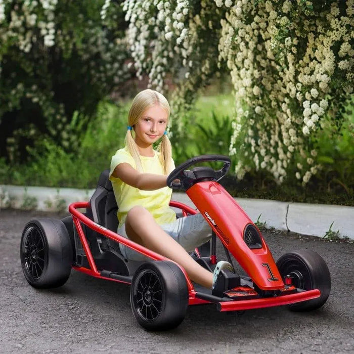Girl driving red 24V kids electric drift go kart outdoors with flowers in background