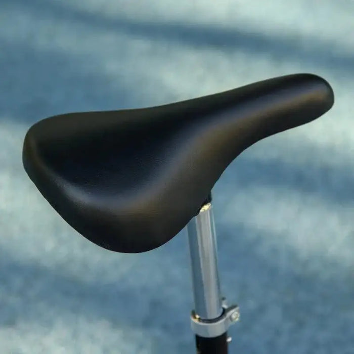 Close-up of black seat on kids' ride-on powered scooter against blue background