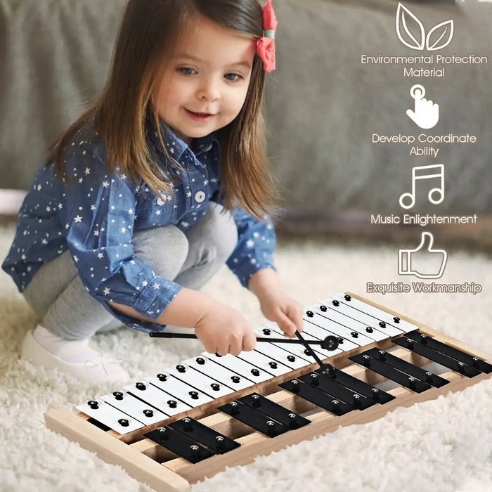 Young girl playing wooden 27-note glockenspiel xylophone on carpet with promotional icons
