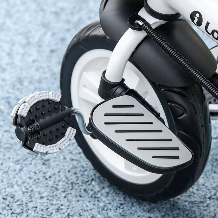 Close-up of a children's electric scooter with visible brand logo on a textured surface.