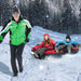 Man in green jacket pulling two kids on a red and black inflatable snow tube in snowy forest