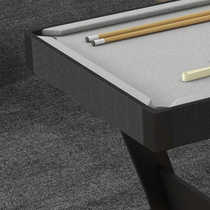 Compact gray pool table with cues and triangle rack on carpeted floor