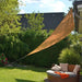 Beige triangular sun shade sail for UV protection over garden patio seating