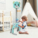 Child playing with a toy in a nursery room with a crib, tepee, and baby monitor.