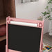 Pink 3-in-1 kids easel with chalkboard, paper roll, and storage baskets in playroom setting