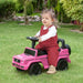 Toddler riding pink Mercedes Benz G350 kids sliding car toy on grass in garden