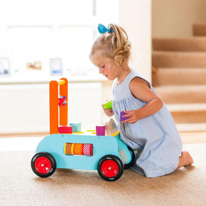 Toddler playing with colorful 3-in-1 activity push-along trolley walker shape sorter