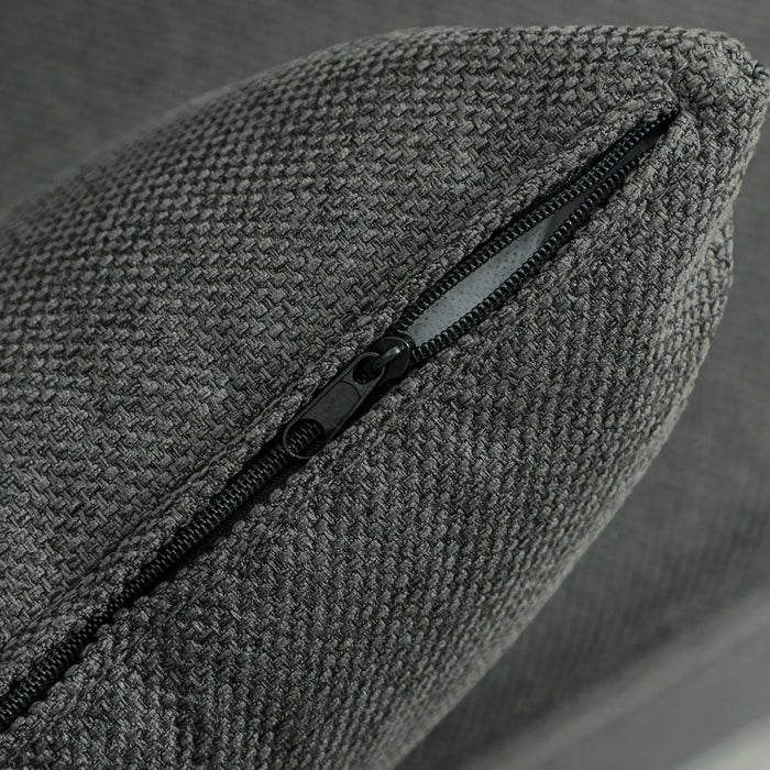 Gray textured pillow with a zipper on a neutral background