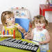 Two young girls playing musical toys indoors, one with wooden mallet and other with xylophone mallets