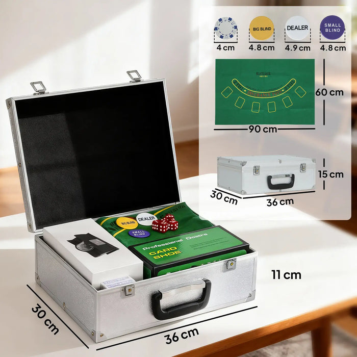 Open silver poker chip case with green blackjack mat, dice, dealer buttons, card shoe, and shuffler on table