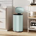 Light blue trash can with a black interior in a kitchen setting