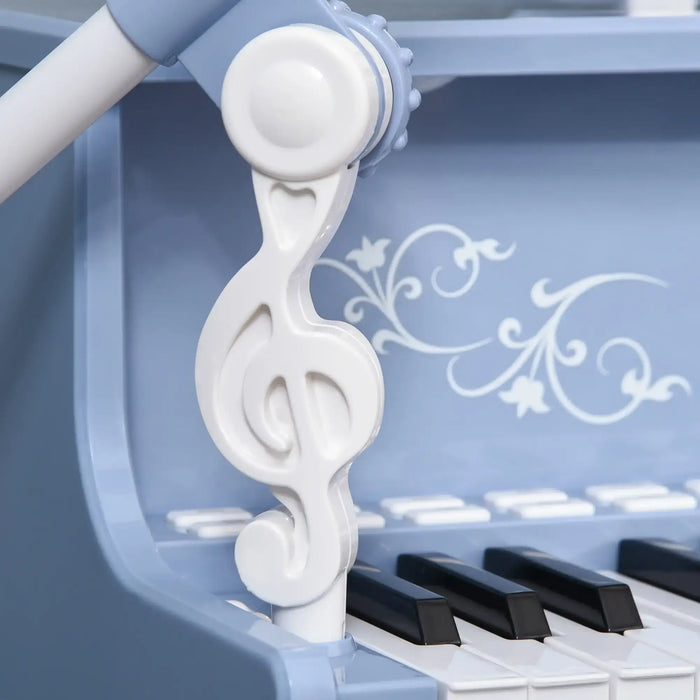 Close-up of blue kids piano with white treble clef detail and black keys